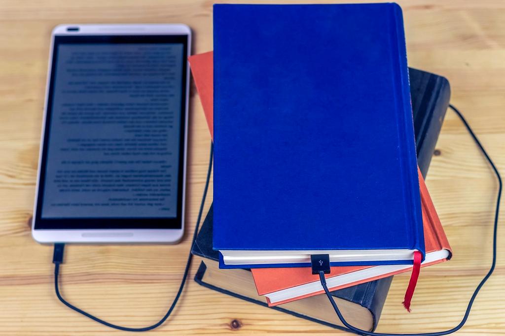 Open book with digital technology icons floating above